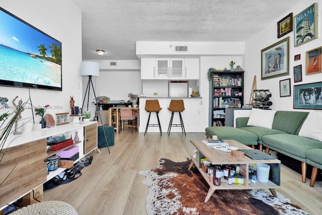 living room featuring a textured ceiling and light hardwood / wood-style floors