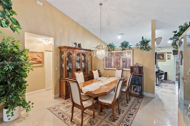 dining space with light tile flooring, high vaulted ceiling, and a notable chandelier