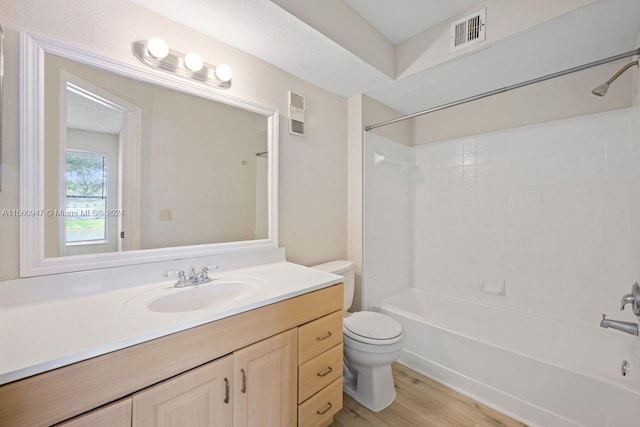 full bathroom featuring toilet, vanity with extensive cabinet space, bathtub / shower combination, and wood-type flooring