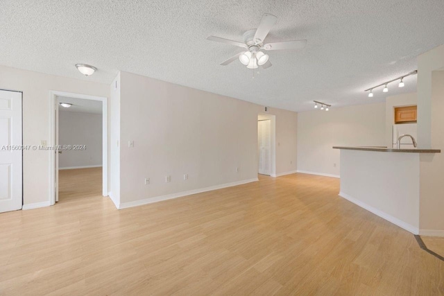 unfurnished room featuring light hardwood / wood-style floors, a textured ceiling, ceiling fan, and track lighting