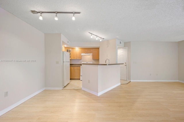 kitchen with range, white fridge, track lighting, light hardwood / wood-style flooring, and a textured ceiling