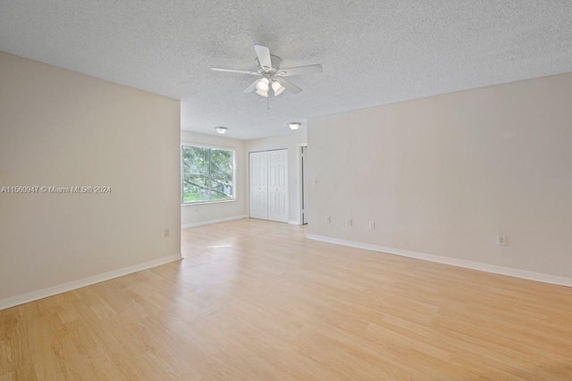 unfurnished room featuring light hardwood / wood-style floors, ceiling fan, and a textured ceiling