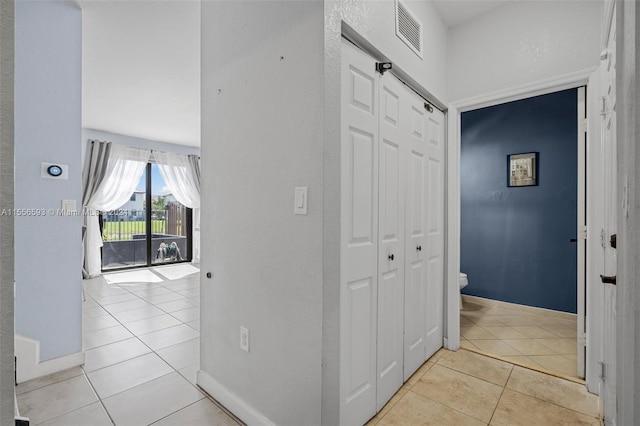 corridor featuring light tile floors