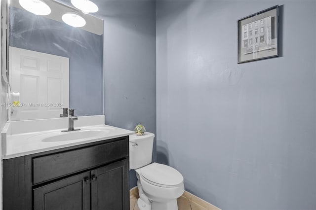 bathroom with tile flooring, large vanity, and toilet