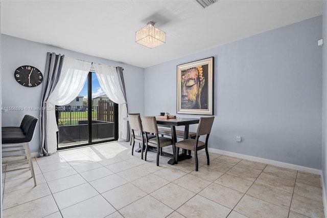 tiled dining room featuring a notable chandelier