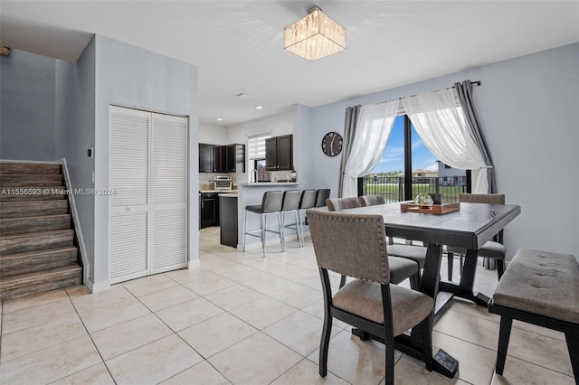 dining area with light tile floors and a notable chandelier