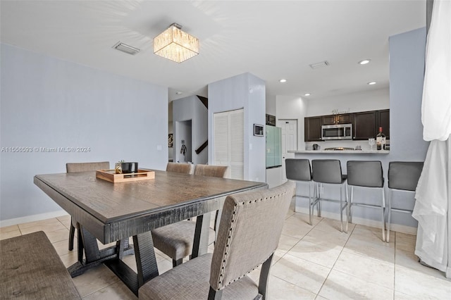 dining space featuring light tile floors and a notable chandelier