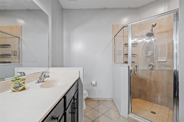 bathroom with toilet, tile floors, a shower with shower door, and large vanity