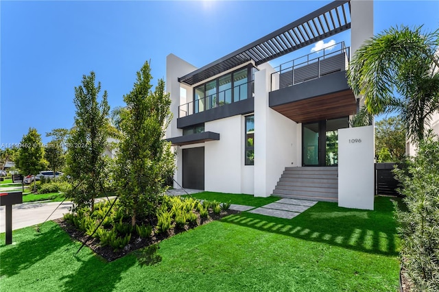 exterior space with a balcony and a lawn