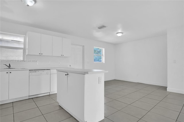 kitchen featuring a center island, light tile floors, sink, white dishwasher, and white cabinetry