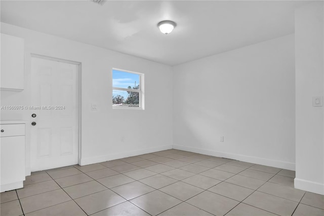 unfurnished room with light tile flooring