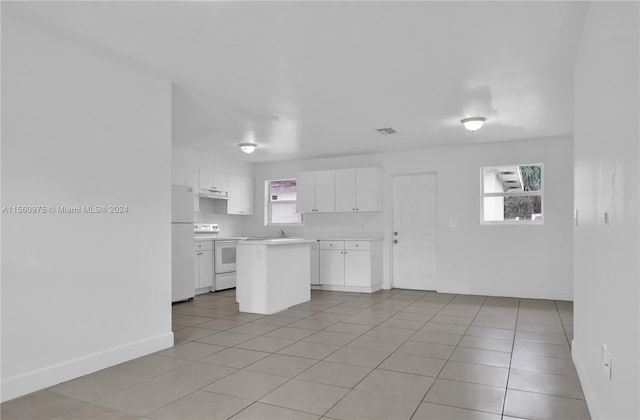 kitchen with white cabinets, light tile floors, white appliances, and sink