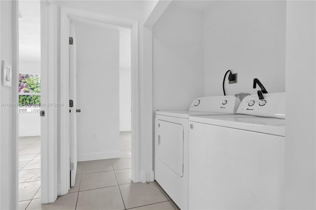 washroom with electric dryer hookup, light tile floors, and washer and dryer