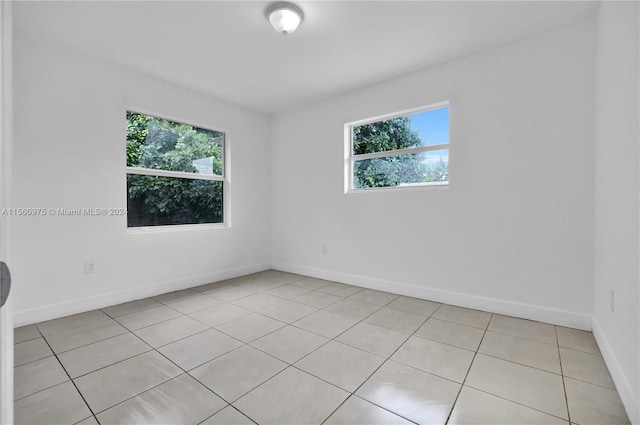 spare room featuring plenty of natural light and light tile flooring