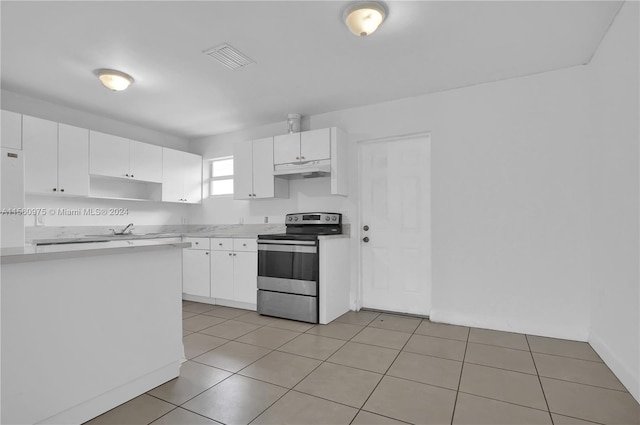 kitchen featuring stainless steel electric range oven, sink, light tile flooring, and white cabinets