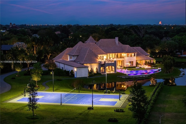 view of pool featuring a yard and basketball hoop