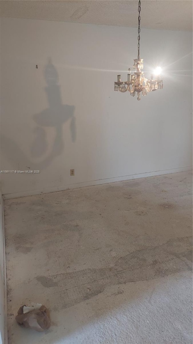 unfurnished room with an inviting chandelier and a textured ceiling