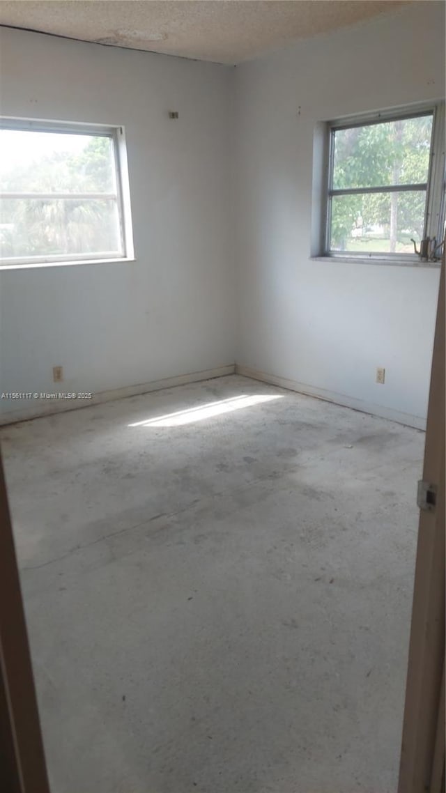 empty room with a healthy amount of sunlight and a textured ceiling