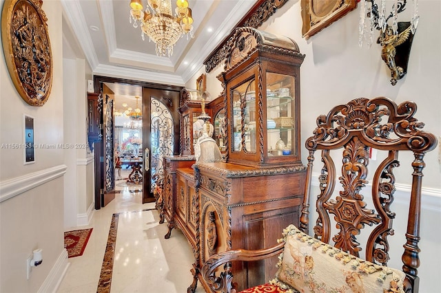 corridor with crown molding, a raised ceiling, light tile floors, and an inviting chandelier