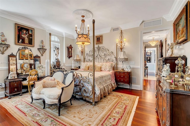 bedroom with crown molding, an inviting chandelier, and wood-type flooring