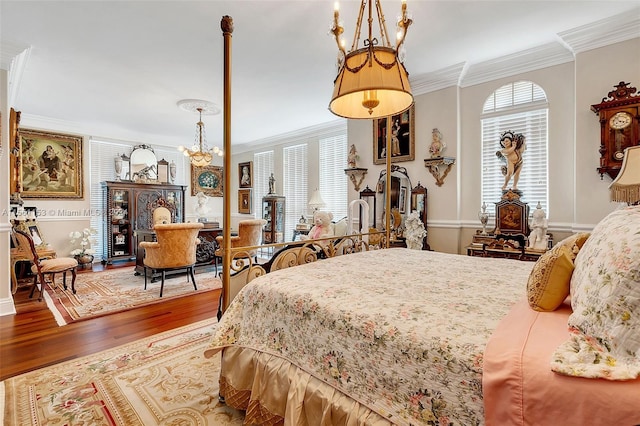 bedroom with an inviting chandelier, ornamental molding, and hardwood / wood-style flooring