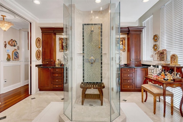 bathroom featuring tile flooring, a shower with shower door, ornate columns, and ornamental molding