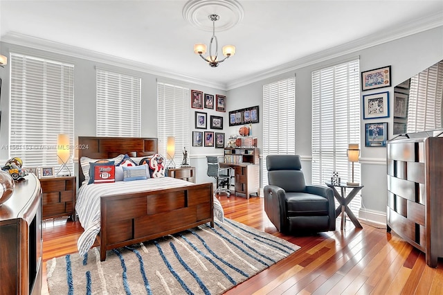 bedroom featuring crown molding, a notable chandelier, and light hardwood / wood-style flooring