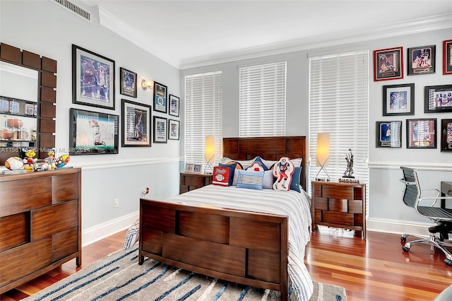 bedroom featuring ornamental molding and light wood-type flooring