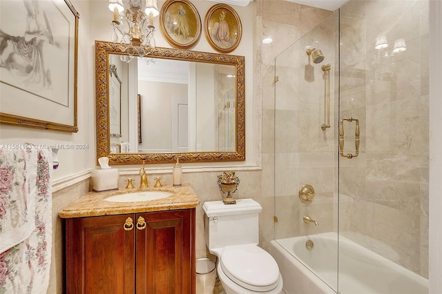 full bathroom featuring tile walls, toilet, vanity, combined bath / shower with glass door, and a notable chandelier