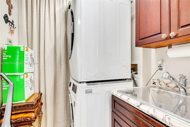 laundry area featuring washer hookup, stacked washer / dryer, cabinets, and sink