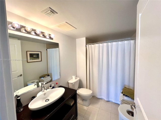 bathroom with toilet, tile floors, and vanity