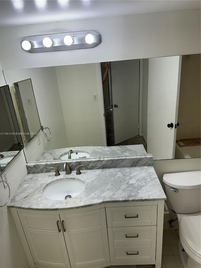 bathroom with tile patterned floors, vanity, and toilet