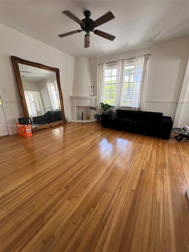 unfurnished living room with hardwood / wood-style flooring and ceiling fan