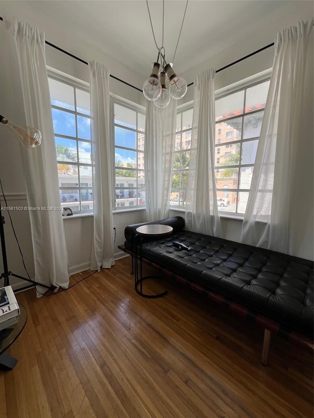 living area featuring hardwood / wood-style flooring and a notable chandelier