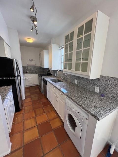 kitchen featuring tile flooring, sink, white cabinetry, washer / dryer, and track lighting