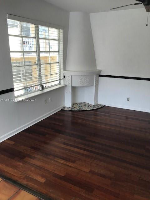 interior space with ceiling fan and dark wood-type flooring