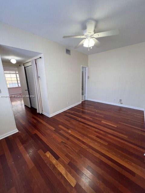 spare room featuring dark hardwood / wood-style flooring and ceiling fan