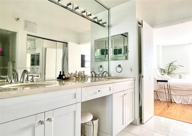 bathroom with double vanity and tile patterned flooring