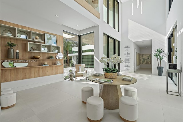 interior space featuring a towering ceiling and light tile patterned flooring