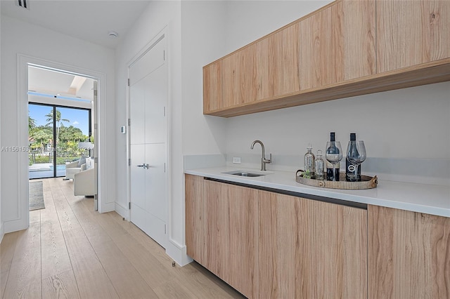 kitchen featuring light brown cabinets, light hardwood / wood-style flooring, and sink