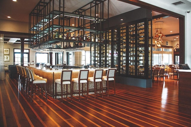 bar featuring hardwood / wood-style floors and a high ceiling