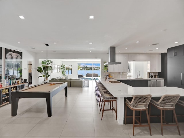 interior space featuring sink, light tile floors, island exhaust hood, white cabinets, and billiards