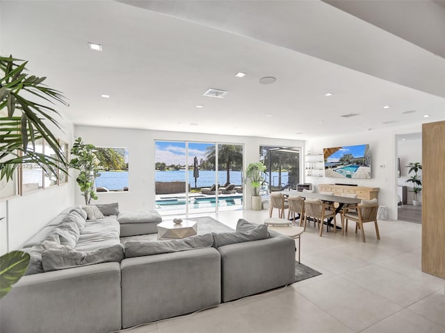 tiled living room featuring a water view