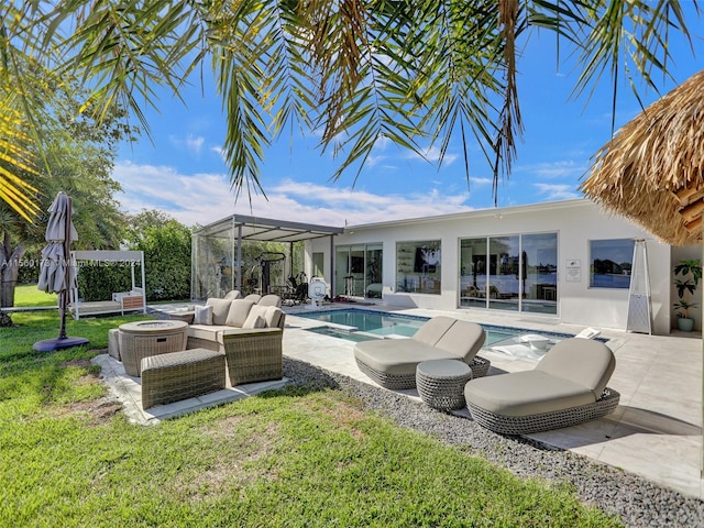 view of pool with an outdoor living space, a patio area, and a lawn