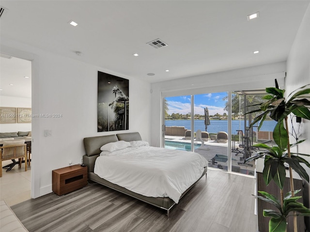 tiled bedroom featuring access to outside and a water view