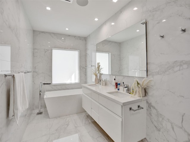 bathroom featuring dual vanity, tile flooring, a bath to relax in, and tile walls