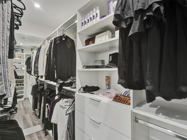 walk in closet with light hardwood / wood-style floors