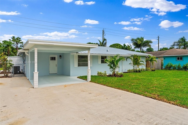 ranch-style home with a carport and a front lawn