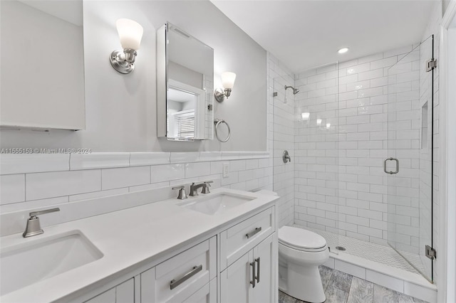 bathroom with vanity, backsplash, walk in shower, tile walls, and toilet