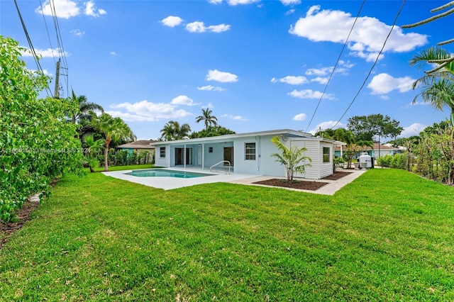 rear view of house with a lawn and a patio